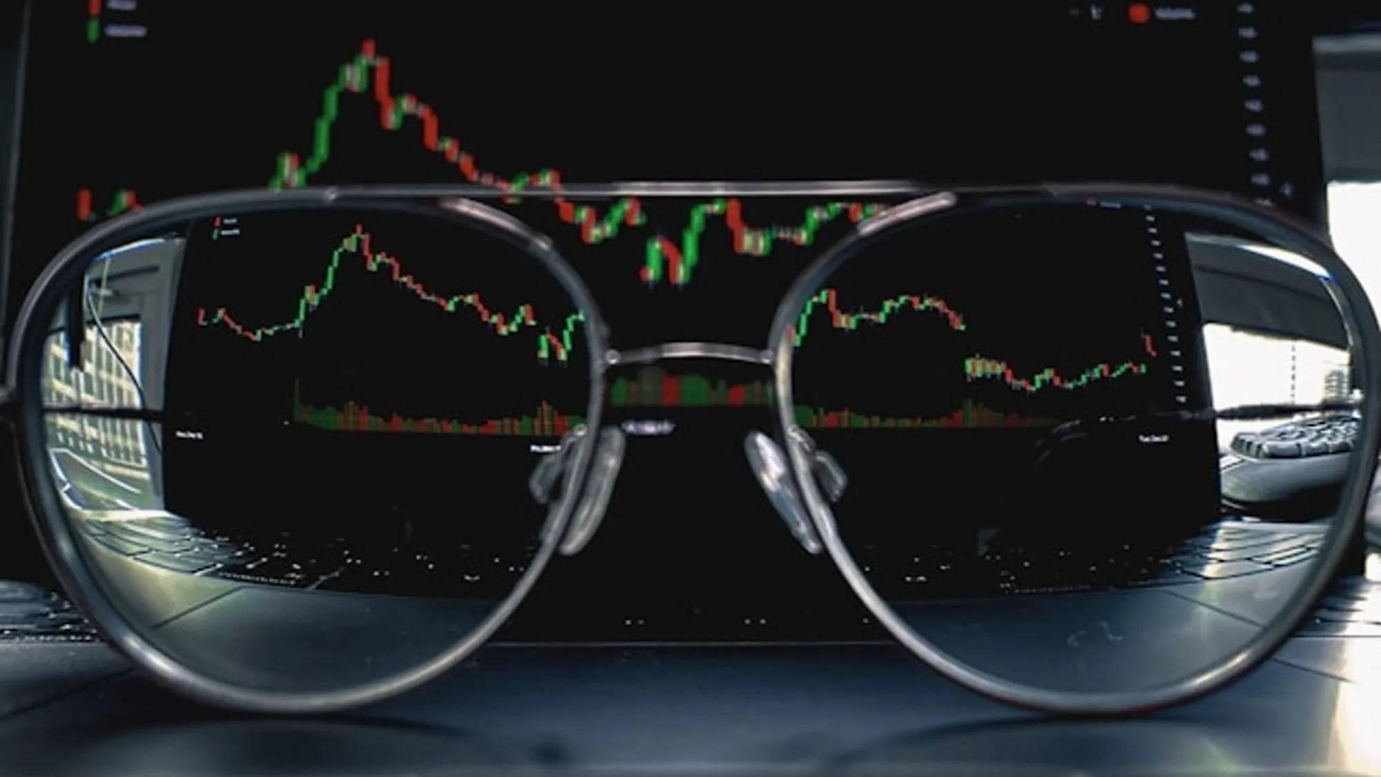 Glasses on laptop having a background screen of market valuation